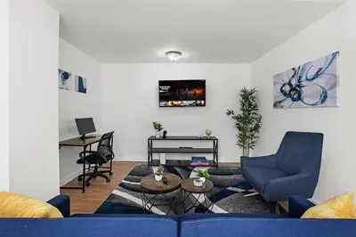 a living room with a blue couch and a piano at Comfy Cozy retreat - NYC & NWK w free parking in Bayonne