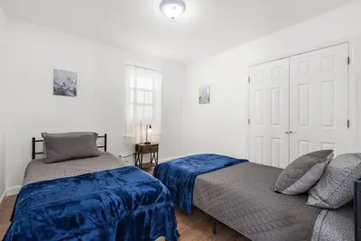a bedroom with two beds and a couch at Comfy Cozy retreat - NYC & NWK w free parking in Bayonne