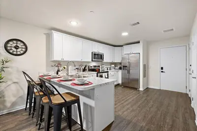 a kitchen with white cabinets and a table and chairs at Family & Traveler Haven - NYC & NWK w/free parking in Newark
