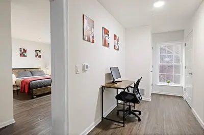 a bedroom with a bed and a desk with a computer at Family & Traveler Haven - NYC & NWK w/free parking in Newark