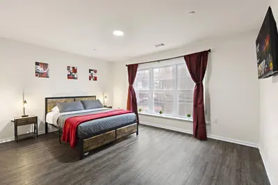 a bedroom with a bed and a large window at Family & Traveler Haven - NYC & NWK w/free parking in Newark
