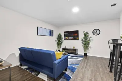 a living room with a blue couch and a clock at Home Sweet Home - near NWK & NYC w/free parking in Newark