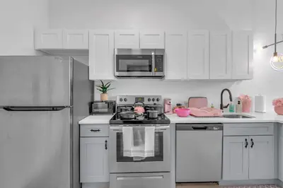 a white kitchen with a stove and a refrigerator at Pink Heaven Indoor Pool, FREE Parking, Near NYC in Elizabeth