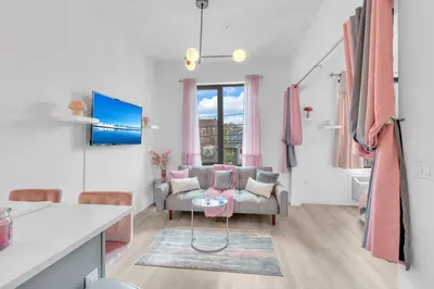 a living room with a couch and a table at Pink Heaven Indoor Pool, FREE Parking, Near NYC in Elizabeth