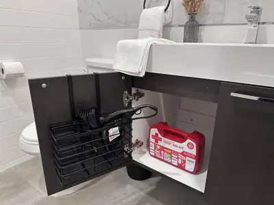 a bathroom with a sink and a red toolbox under a sink at Cozy Stylish retreat - NYC & NWK w free parking in Bayonne