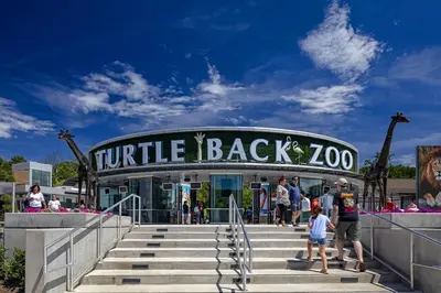 a group of people standing in front of a turtle back zoo at Cozy Stylish retreat - NYC & NWK w free parking in Bayonne