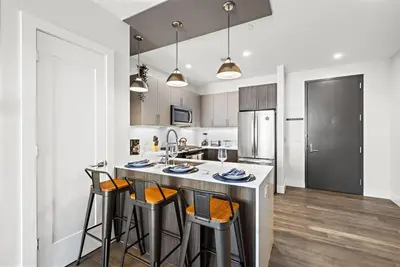 a kitchen with a counter with stools in it at Cozy Stylish retreat - NYC & NWK w free parking in Bayonne