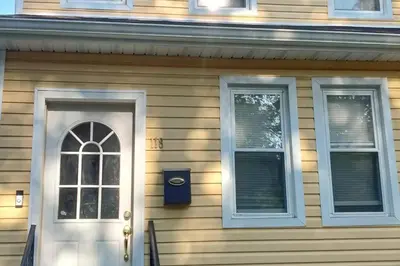 a house with a white door and two windows at Hollywood in East Orange