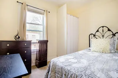 a bedroom with a bed and a dresser and a window at Hollywood in East Orange