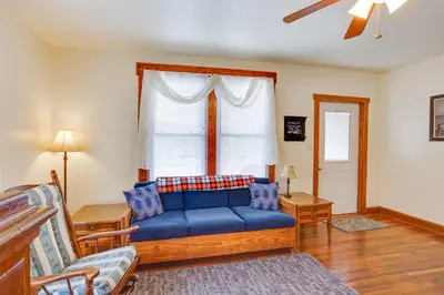 a living room with a blue couch in front of a window at Amish Country Townhome Near Hiking and Fly Fishing! in Loganton