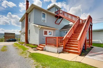 a house with a deck and stairs on it at Amish Country Townhome Near Hiking and Fly Fishing! in Loganton