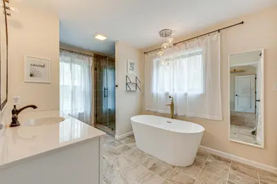a white bathroom with a tub and a sink at Lakefront Long Pond Home with Wraparound Deck! in Long Pond
