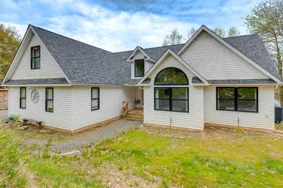a white house with a gambrel roof at Lakefront Long Pond Home with Wraparound Deck! in Long Pond
