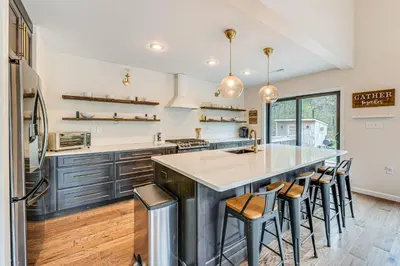a kitchen with a large island with bar stools at Lakefront Long Pond Home with Wraparound Deck! in Long Pond
