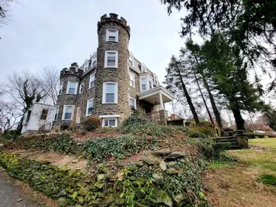 a large building on top of a hill at 1 Bedroom 1 Bath Apartment In Melrose Park in Elkins Park