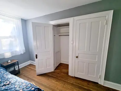 a bedroom with white doors and a bed and a window at 1 Bedroom 1 Bath Apartment In Melrose Park in Elkins Park