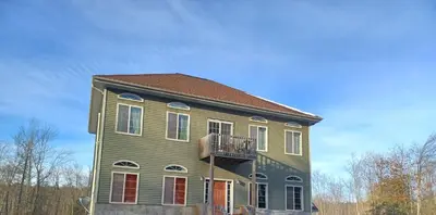 a green house with a balcony on top of it at Harvey's Lake/near Rickett's Glen in Harveys Lake