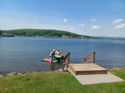 two people standing on a raft in the water next to a dock at Harvey's Lake/near Rickett's Glen in Harveys Lake