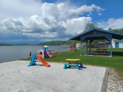a playground with slides and play equipment next to the water at Harvey's Lake/near Rickett's Glen in Harveys Lake