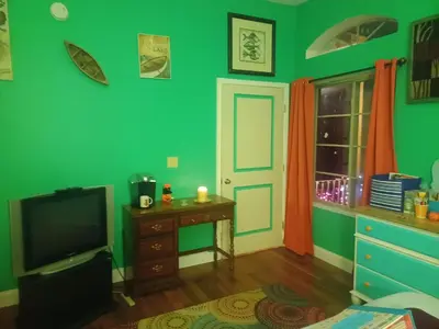 a green room with a tv and a desk and a window at Harvey's Lake/near Rickett's Glen in Harveys Lake