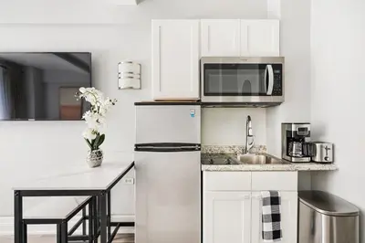 a white kitchen with a refrigerator and a sink at 73-318 New Studio UWS Doorman Gym in New York