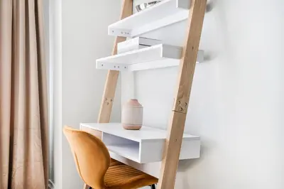 a ladder with white shelves next to a chair at 73-318 New Studio UWS Doorman Gym in New York