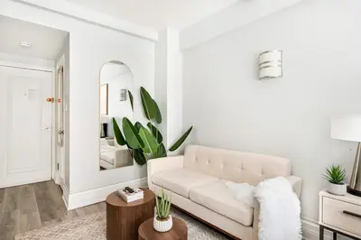 a living room with a white couch and a mirror at 73-318 New Studio UWS Doorman Gym in New York