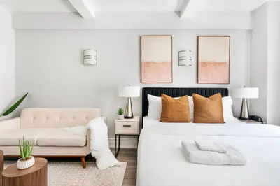a white bedroom with a bed and a couch at 73-318 New Studio UWS Doorman Gym in New York