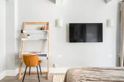 a bedroom with a bed and a desk and a tv at 73-1503 Newly Reno Studio UWS Doorman Gym Laundry in New York
