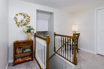 a hallway with a staircase with a mirror on the wall at 5mi to Big Boulder Hot tub Patio Firepit Fast WiFi in Blakeslee