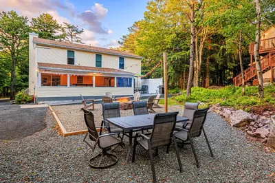 a table and chairs in front of a house at 5mi to Big Boulder Hot tub Patio Firepit Fast WiFi in Blakeslee