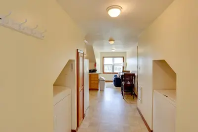 a hallway with a staircase leading to a living room at Loganton Townhome, Near Fly Fishing and Hiking! in Loganton