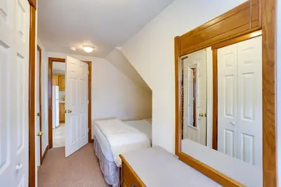 a small bedroom with two beds and two doors at Loganton Townhome, Near Fly Fishing and Hiking! in Loganton