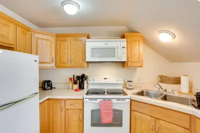 a kitchen with a white stove top oven next to a sink at Loganton Townhome, Near Fly Fishing and Hiking! in Loganton