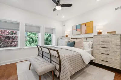 a bedroom with a bed and a dresser and windows at Family Friendly in the Heart of Mt Airy in Philadelphia