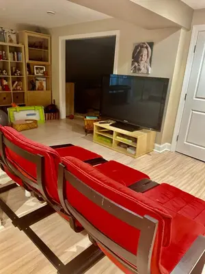 a living room with a flat screen tv and a red couch at House in Bucks County in Perkasie