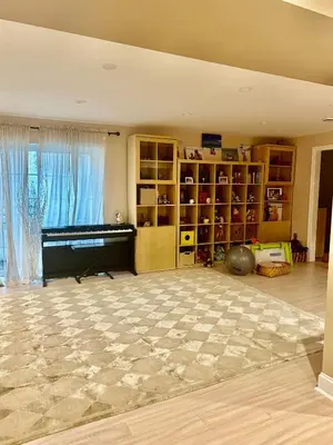 a living room with a piano and a book shelf at House in Bucks County in Perkasie