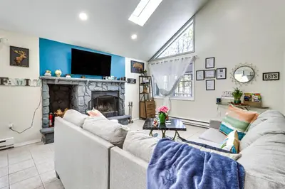a living room with a couch and a fireplace at Hot Tub and Lake Beach Access Tobyhanna Retreat! in Tobyhanna