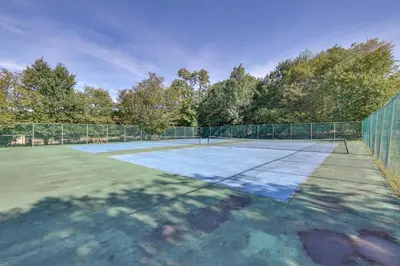 a tennis court with a net on top of it at Hot Tub and Lake Beach Access Tobyhanna Retreat! in Tobyhanna