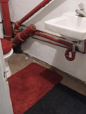 a bathroom with red pipes and a sink and a red rug at Victorian Home Sleeps 10 Fenced 4BR Full Kitchen Steps2 YCP in York