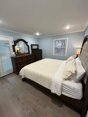 a bedroom with a bed and a dresser and a mirror at Huge Family House 12 miles to NYC4BathParking in Belleville