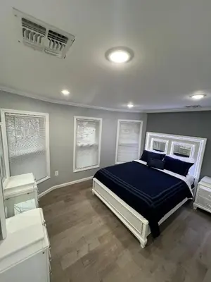 a bedroom with a bed with blue sheets and windows at Huge Family House 12 miles to NYC4BathParking in Belleville