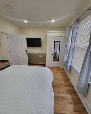 a bedroom with a white bed and a flat screen tv at OoohLaLa! 2 Beds and 2 Full Baths w/Free Parking in Newark