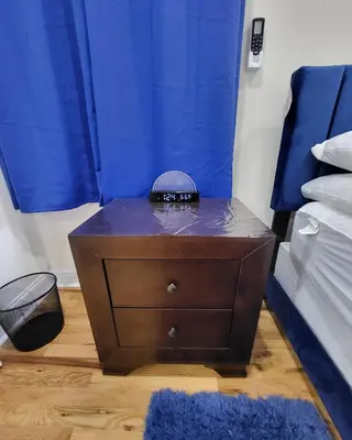 a nightstand with a alarm clock on it in a bedroom at OoohLaLa! 2 Beds and 2 Full Baths w/Free Parking in Newark