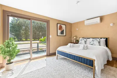 a bedroom with a bed and a large window at Bronze Suite in Greenwood Lake