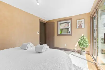 a bedroom with a white bed and a window at Bronze Suite in Greenwood Lake