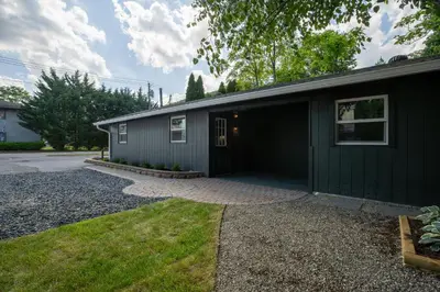 a black house with a garage and a driveway at Bronze Suite in Greenwood Lake