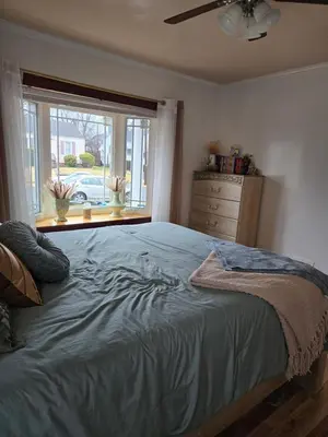 a bedroom with a bed with a window and a dresser at House in New Jersey in Paterson