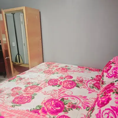 a bed with a pink and white bedspread with pink roses at Divine Villa Guest House Harper Ave WITH FREE PRIVATE PARKING in Irvington