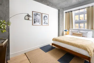 a white bedroom with a bed and a window at Luxury Full Floor Chelsea with WasherDryer 2bd in New York